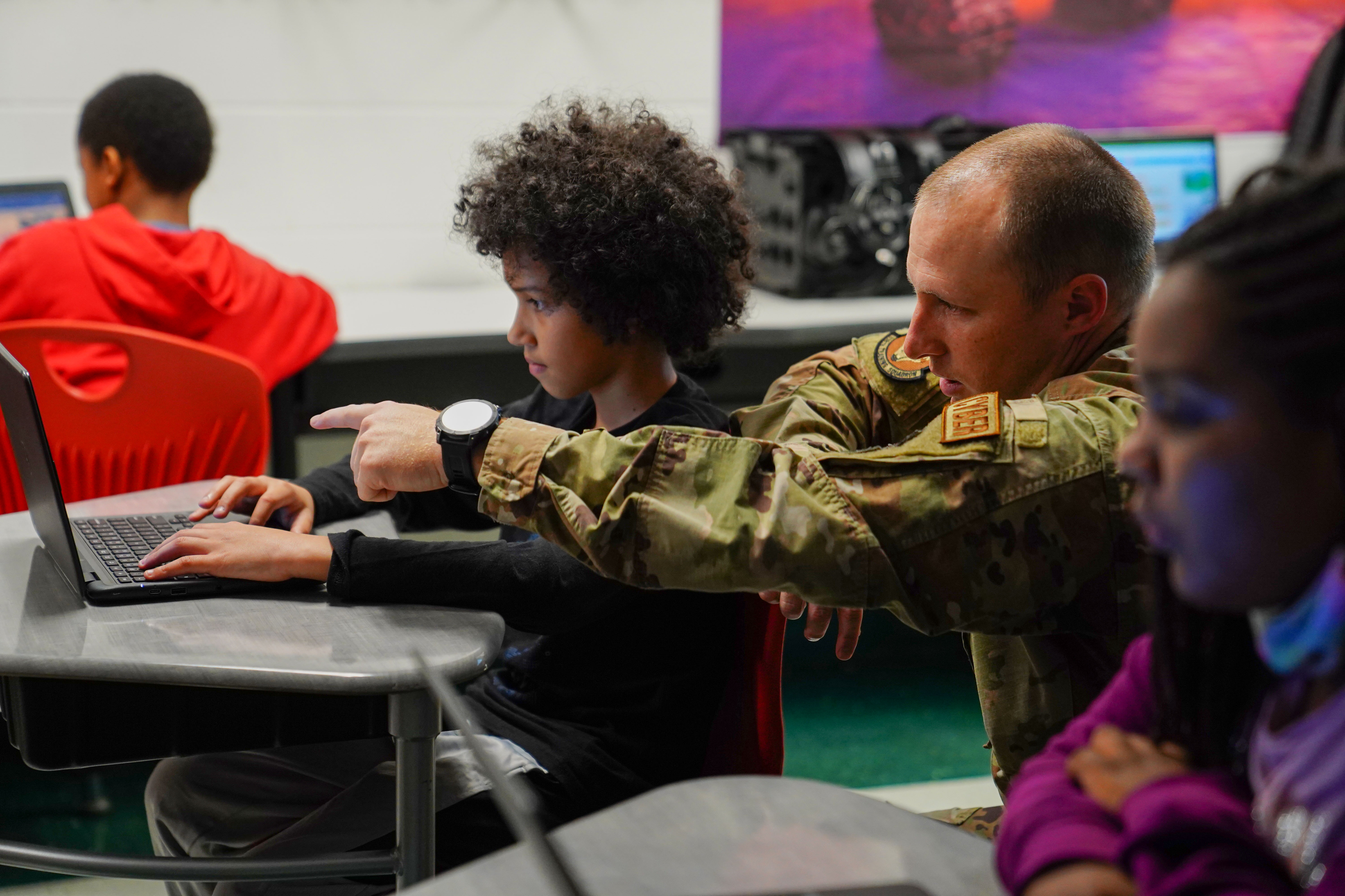 U.S. Tech. Sgt. Shane Balkcom, 336th Training Squadron learning program manager, shows a student how to create basic algorithm blocks at Back Bay Elementary School, Mississippi, on March 23, 2023.